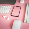 Stylized arrangement of electronic devices on a vibrant pink background, ideal for tech marketing.